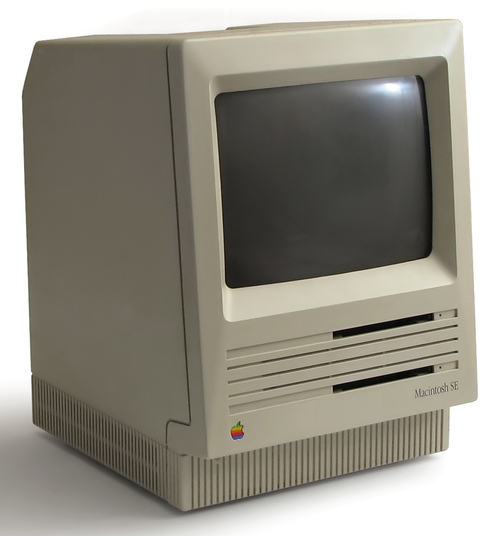 A vintage Apple Macintosh SE personal computer with a CRT display and a beige, boxy design.